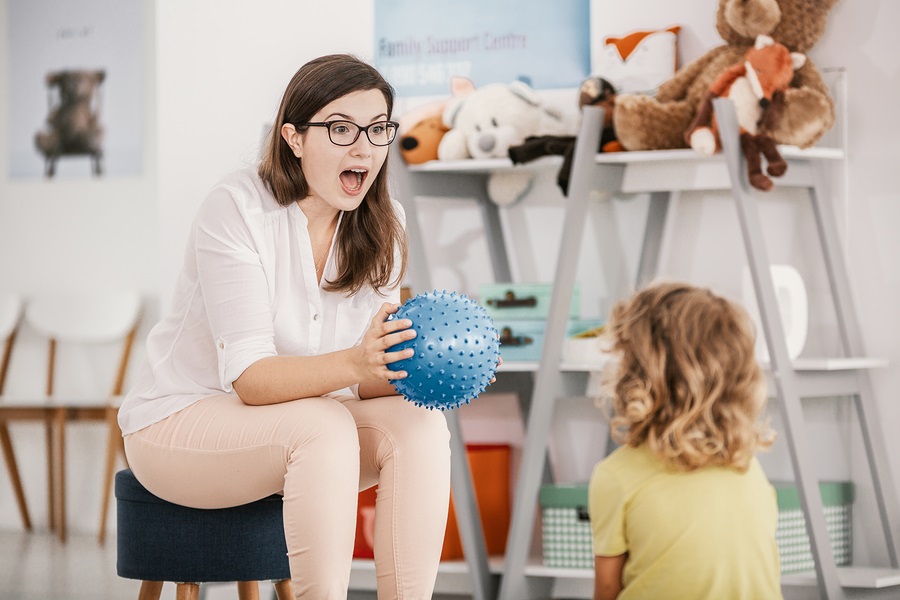 A professional child education therapist having a meeting with a kid in a family support center.